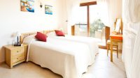 Thumbnail of http://Two%20beds%20with%20white%20sheets%20and%20red%20pillows