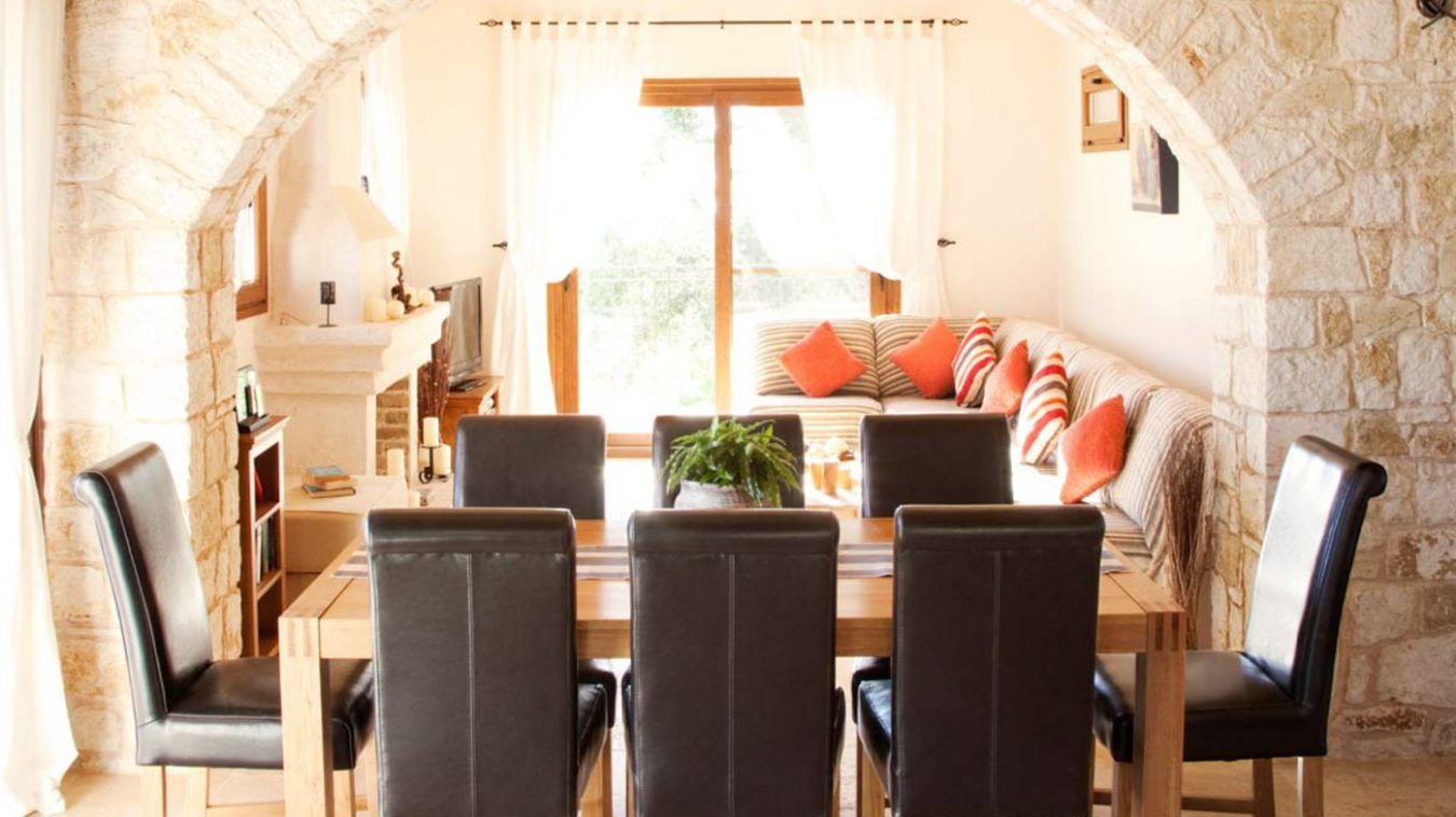 A dining table with 6 leather backed chairs inside the villa