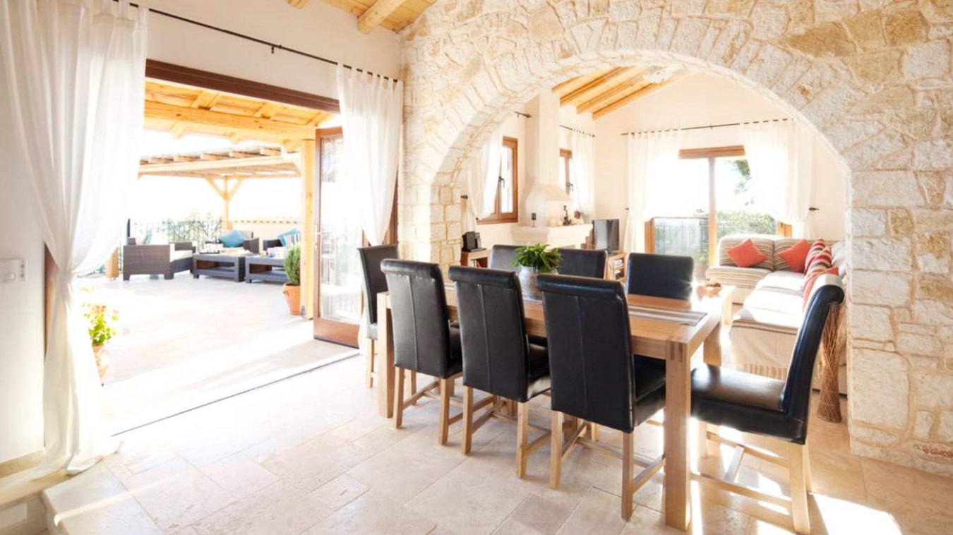 An angled view of the dining table with 6 leather backed chairs